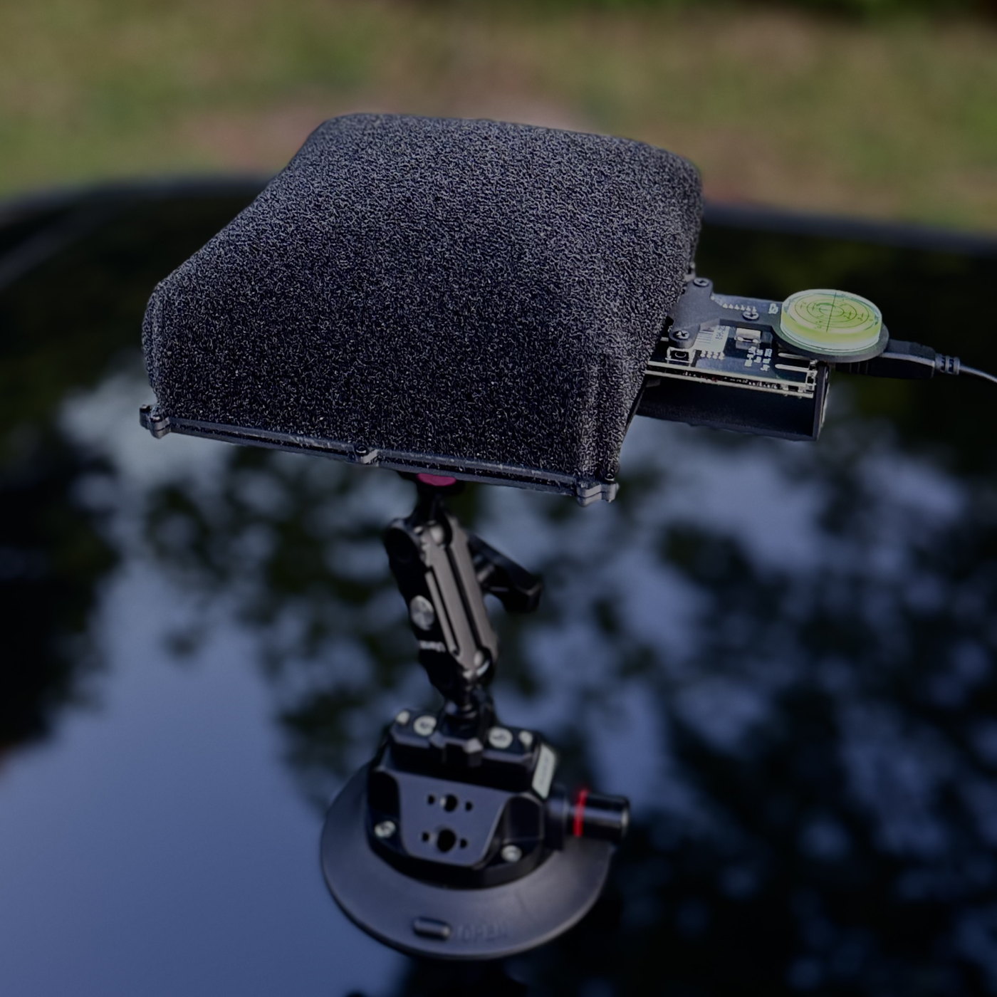 The GW-VNR1 acoustic array head: a foam-covered microphone panel on an articulated suction mount, attached to a vehicle roof.